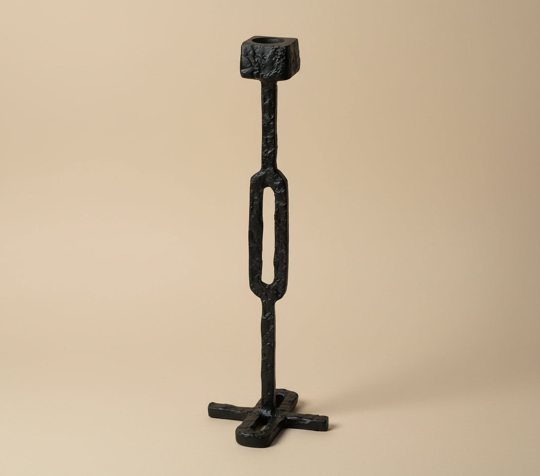 Black metal candle holder with 'Vanik Living' branding on a white background