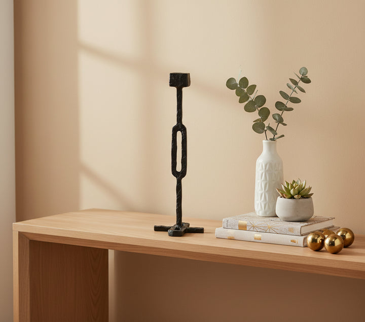 Black metal candle holder with 'vanik living' branding on a white background