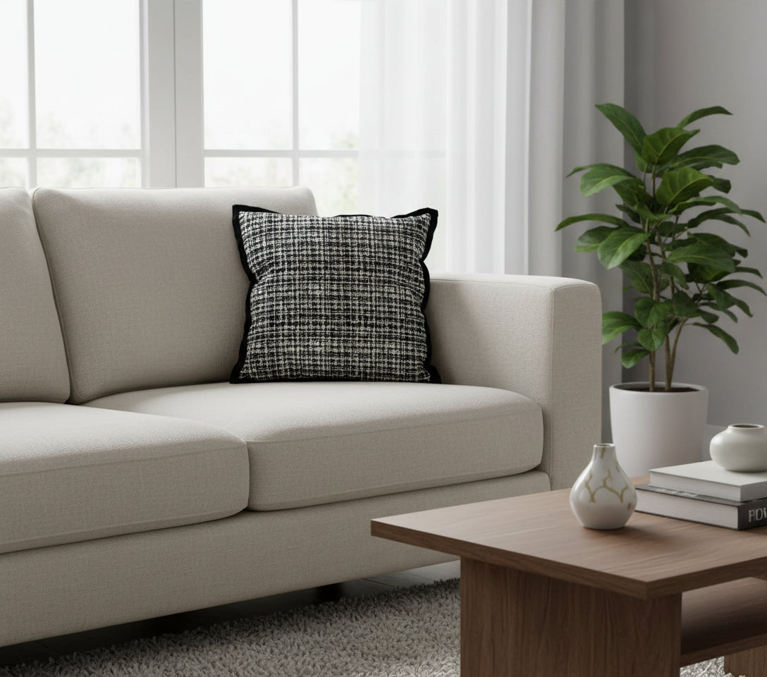 Black and white patterned pillow with Vanik Living  branding on a white background