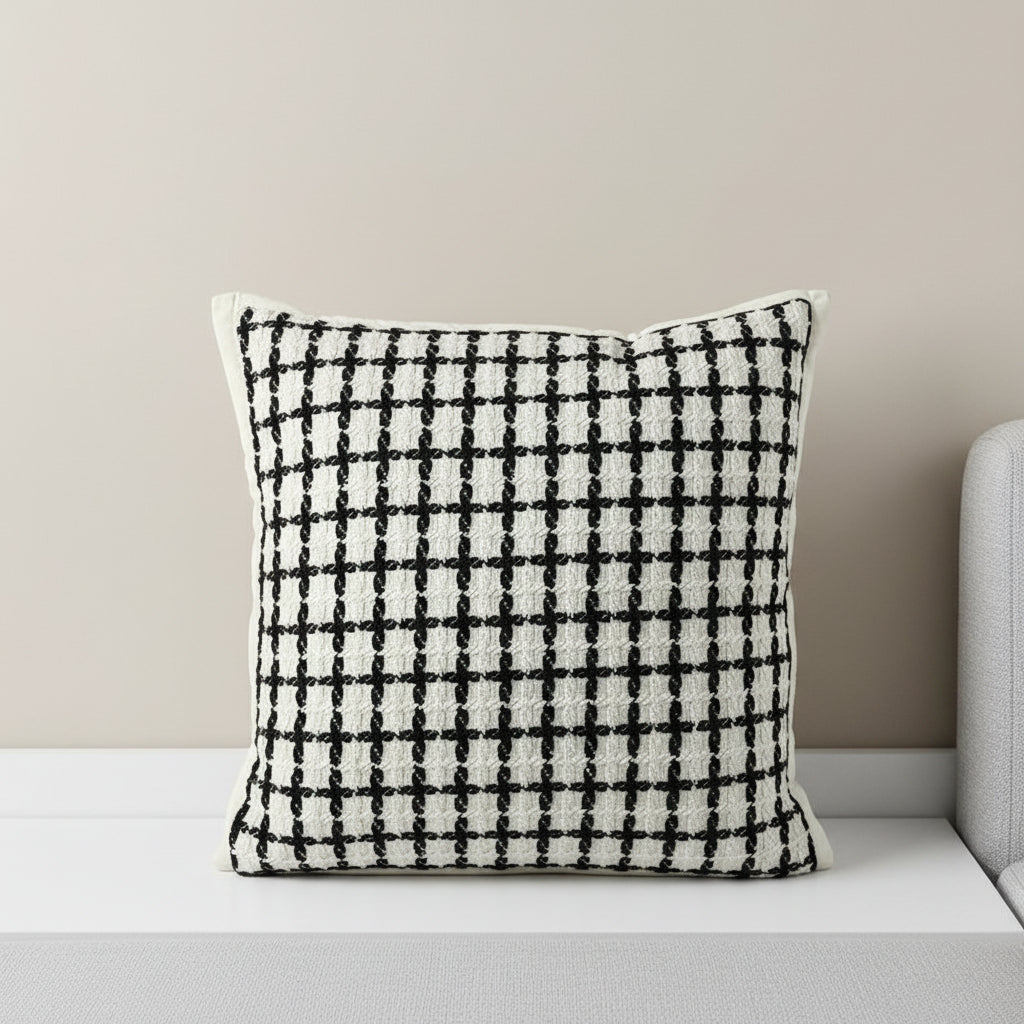 Decorative pillow with black grid pattern on a white background, featuring the brand Vanik Living 