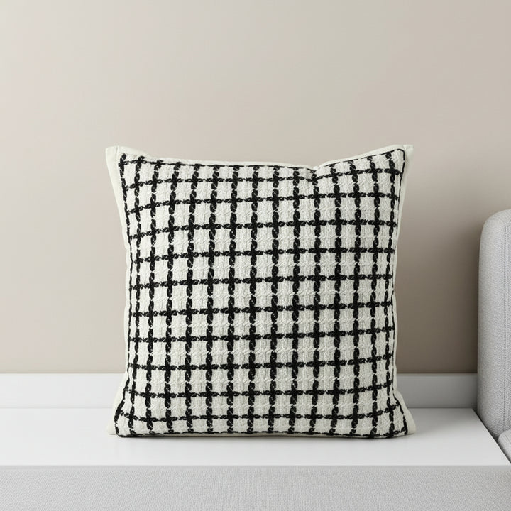 Decorative pillow with black grid pattern on a white background, featuring the brand Vanik Living 